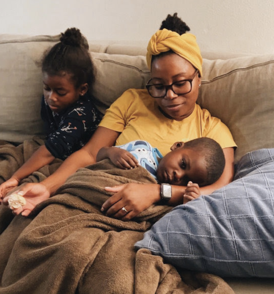 Yvette sitting with her children, Uzi and Anaya, on the couch snuggling.